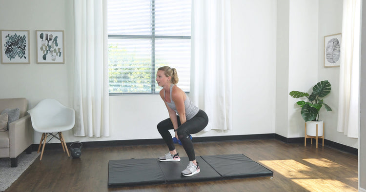 a woman is doing dumbbell workout in living room