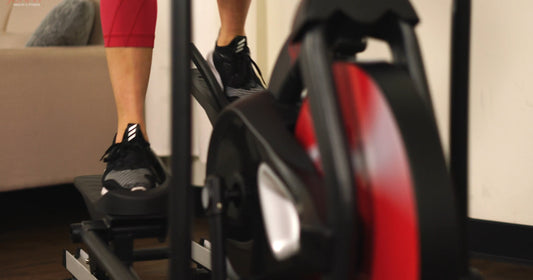 a woman is pedaling elliptical