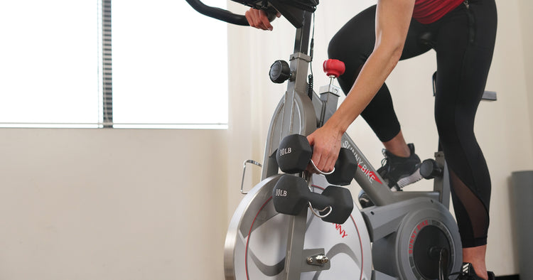 a cycling woman is holding a dumbbell
