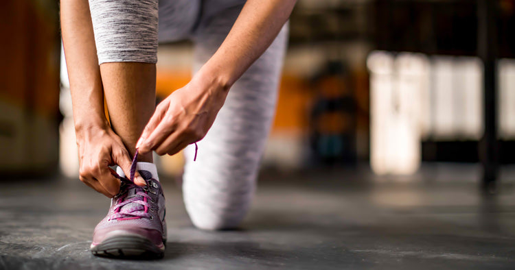 a woman is tying her shoes