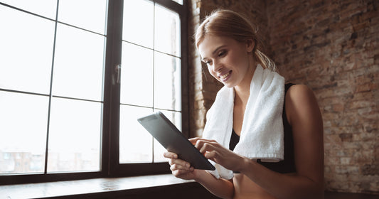 a lady is reading online fitness guide to getting started with home exercise equipment