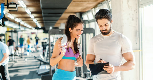 a woman and a man are talking in the gym