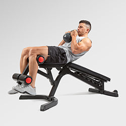 man doing situps on weight bench while holding kettlebell